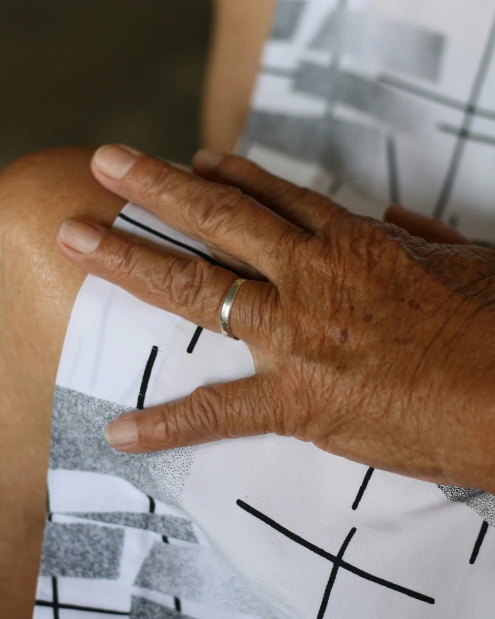 Manos de una abuela descansando sobre su regazo